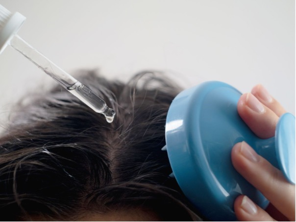 Mladá žena si prohlíží padající vlasy v ruce – ilustrační foto k článku o návycích, které způsobují padání vlasů